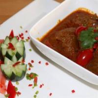 Indian Goat Curry · Chunks of fresh tender goat cooked for hours on low fire with herbs.