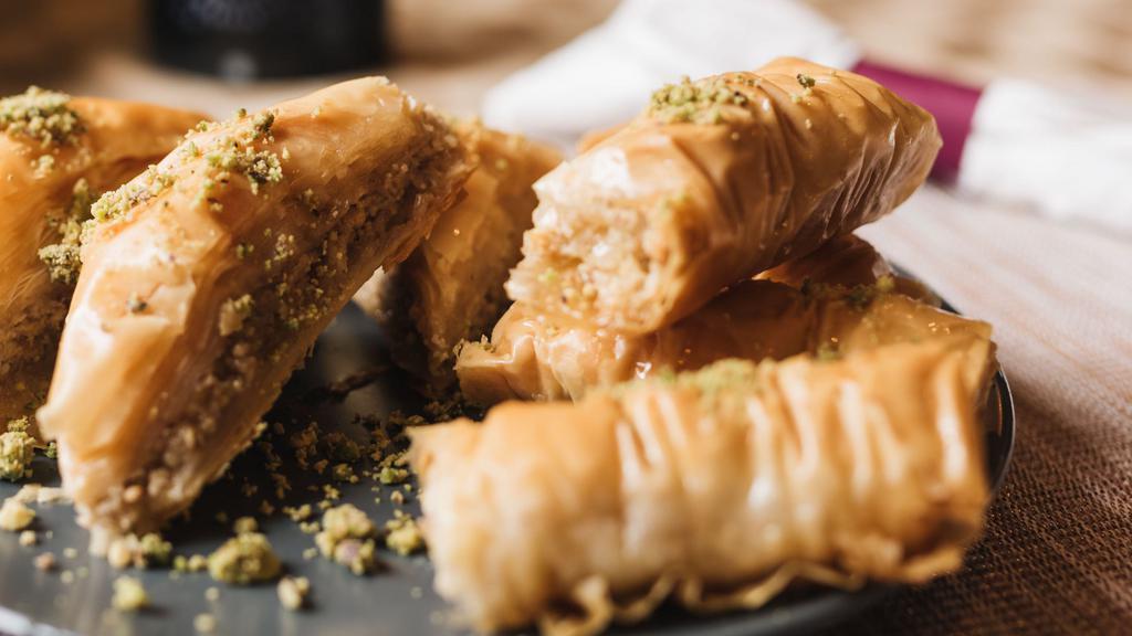 Lady Fingers (3) · Sweet pastry made with extremely thin sheet of phyllo dough layered and rolled with honey syrup, topped with crushed pistachios.