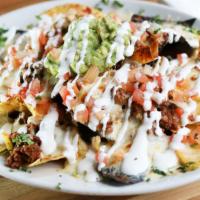 Nachos Supreme · Nachos with cheese, beef, chicken and beans. Topped with lettuce, tomatoes, sour cream and g...