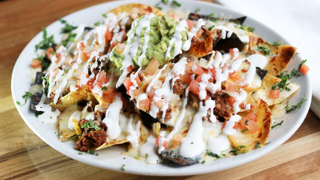 Nachos Fajitas · Nachos with cheese, grilled steak or chicken, onions, tomatoes and bell peppers, topped with lettuce, tomatoes, sour cream. Served with beans.