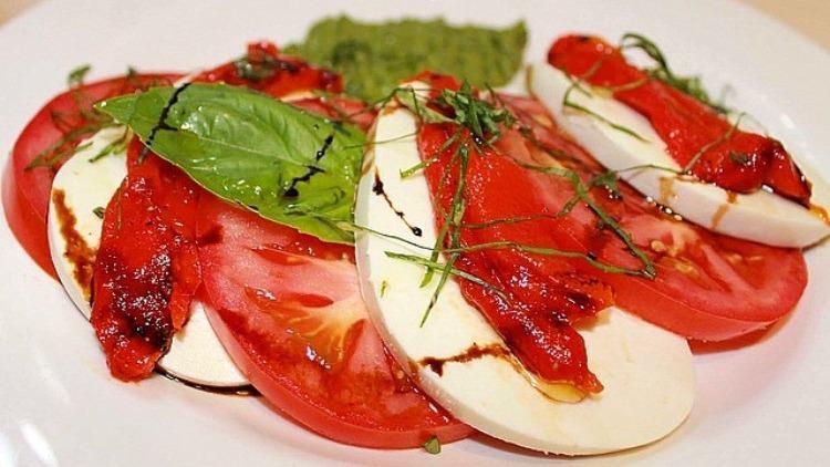 Caprese · Mozzarella, vine-ripened tomatoes, roasted peppers, basil pesto, EVOO.