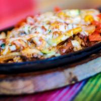 Tropical Fajitas · Grilled chicken with bacon, pineapple, chorizo, bell pepper, onions and mushrooms in our hou...