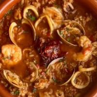 Fam Arroz Caldoso · Valencia style rice, shrimp, chicken, calamari, red sofrito, saffron. Served with a garden s...