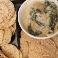 Spinach & Artichoke Dip · A creamy cheese blend with spinach and artichokes, served with tri-color tortilla chips