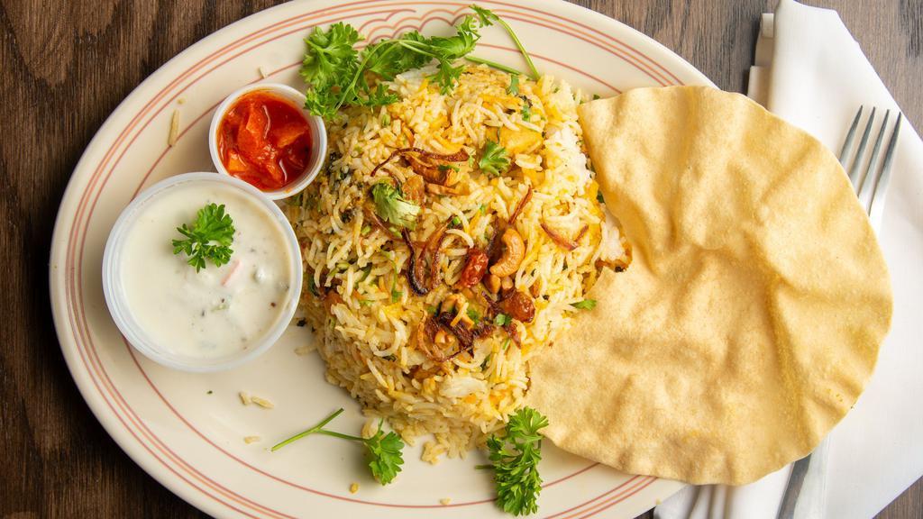 Chicken Dum Biryani · Long grain basmati rice flavored with saffron and cooked with a delicate blend of exotic spices and herbs and chicken, served with raita and curry sauce).