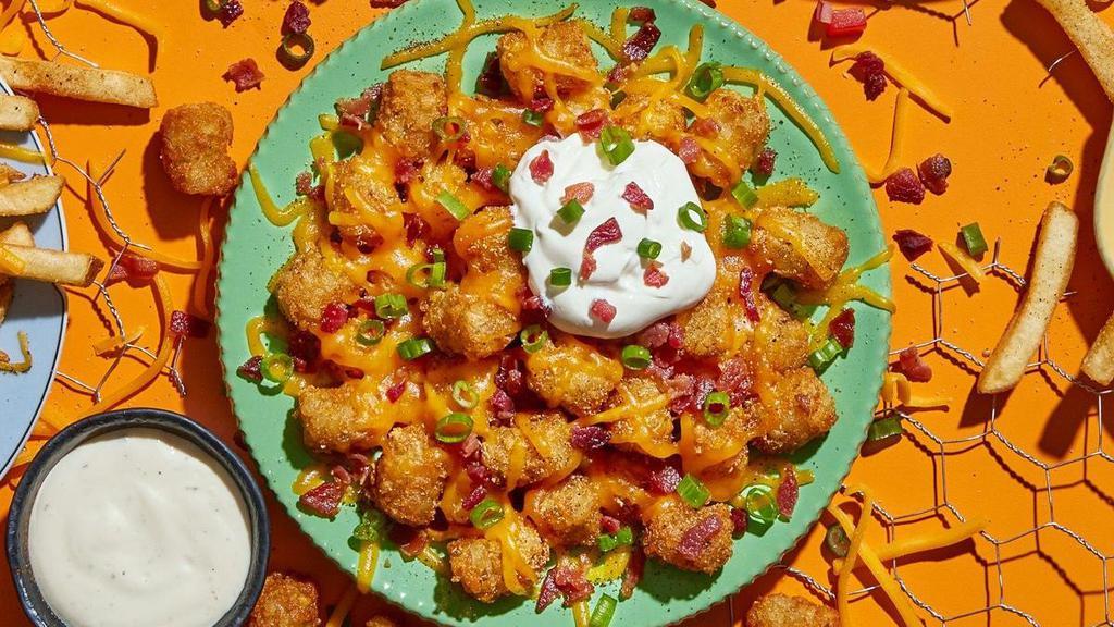 Loaded Tots · Get 'em loaded with cheddar cheese, sour cream, bacon and green onions.