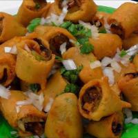 Cut Mirchi · Spicy chilies battered and fried. Garnished with cilantro, onion, and spices. Served with mi...