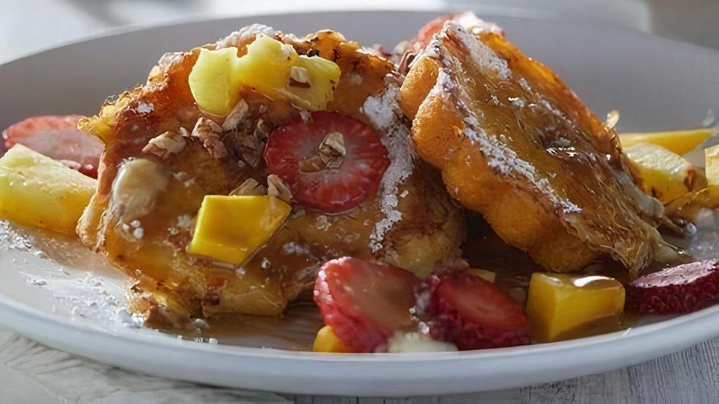 Rum Cake French Toast · French-toast style spiced rum cake with pecans. Topped with grilled fresh pineapple, fresh berries, and a spiced rum butter glaze. MUST BE 21 to order. Served with two eggs any style (add 120 - 220 cal) and baked bacon or house-made sausage patties (add 180/250 cal).