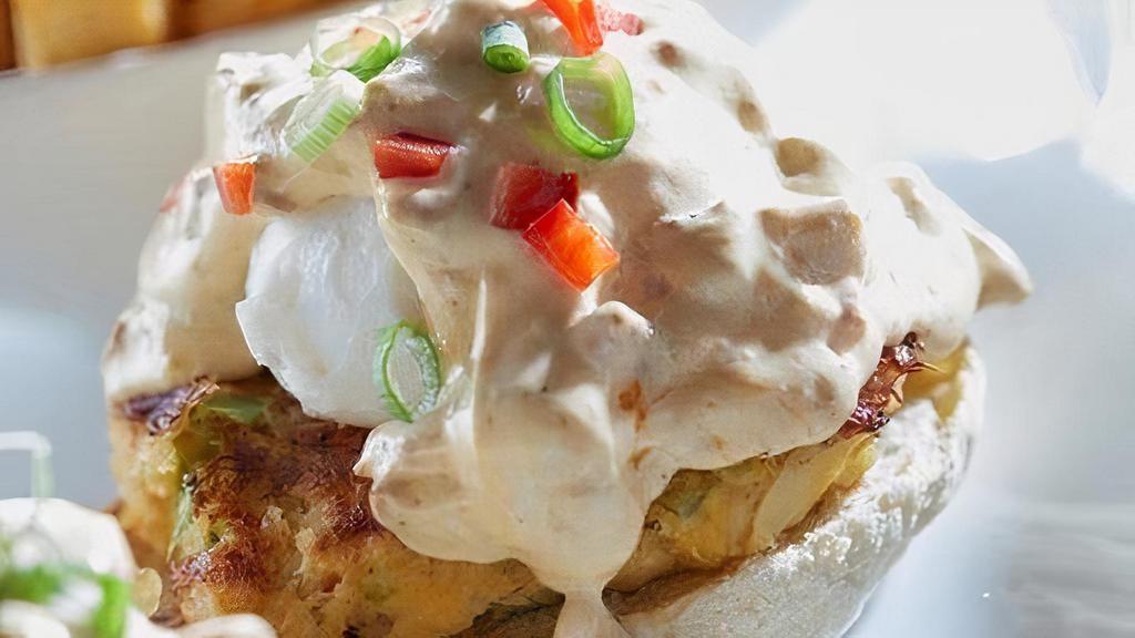 Crab Cake Benedict · Jumbo lump crab cakes on an English muffin, topped with poached eggs, andouille-infused hollandaise, red peppers and green onions.