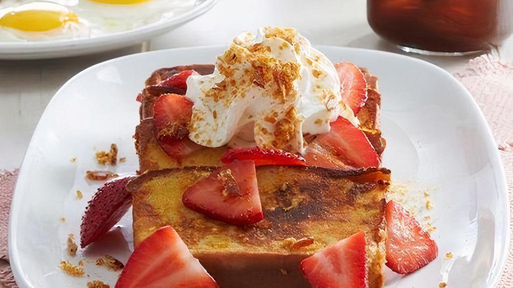 Strawberry Pound Cake French Toast · French toast-style pound cake topped with fresh strawberries, fresh whipped cream and crème brûlée sugar