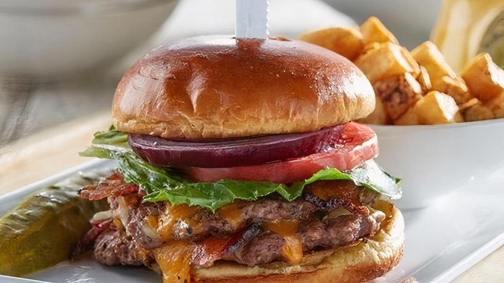 Classic Bacon Burger - Gluten Friendly · Two hand-pressed beef patties, baked bacon, Cheddar Jack cheese, lettuce, tomato and red onion on. Substitute gluten friendly bread for brioche bun. Served with a pickle and grits.