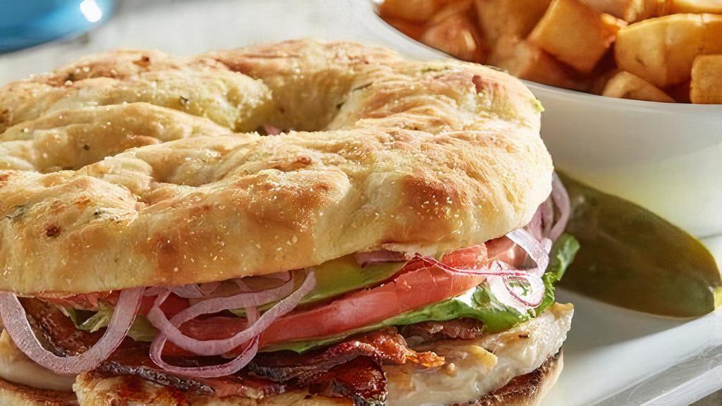 Southern Grilled Chicken Sandwich - Gluten Friendly · Grilled chicken, baked bacon, avocado, lettuce, tomato and pickled red onions with ranch dressing. Substitute gluten friendly bread for focaccia. Served with a pickle and grits.