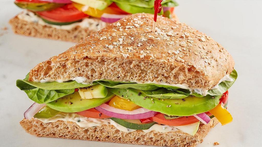 The Veggie · Spinach, tomato, cucumber, red onion, house-roasted multicolored peppers, avocado and herb mayo on 9-grain..