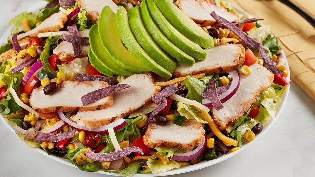 Southwest Chicken & Avocado Salad · Grilled chicken, roasted corn, poblano and black bean relish, red onion, tomato, cheddar-jack, blue corn tortilla strips, avocado on mixed greens.. Try it with Chili Lime Vinaigrette dressing.