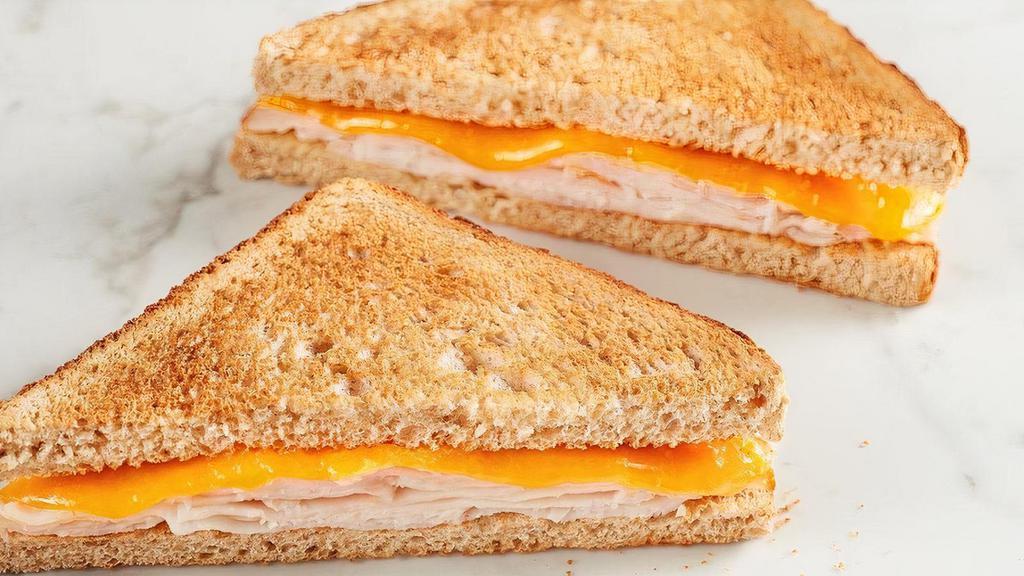 Kids Turkey Toastie · American cheese with turkey on toasted wheat bread. Comes with your choice of a side and a Mini Chocolate Chip Cookie.