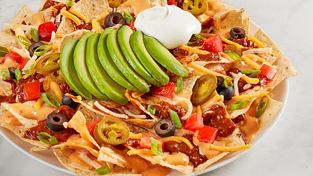 Ultimate Nachos · Chili, RO*TEL cheese sauce, cheddar-jack, tomato, black olives, jalapeños, green onion, avocado and sour cream on tortilla chips.