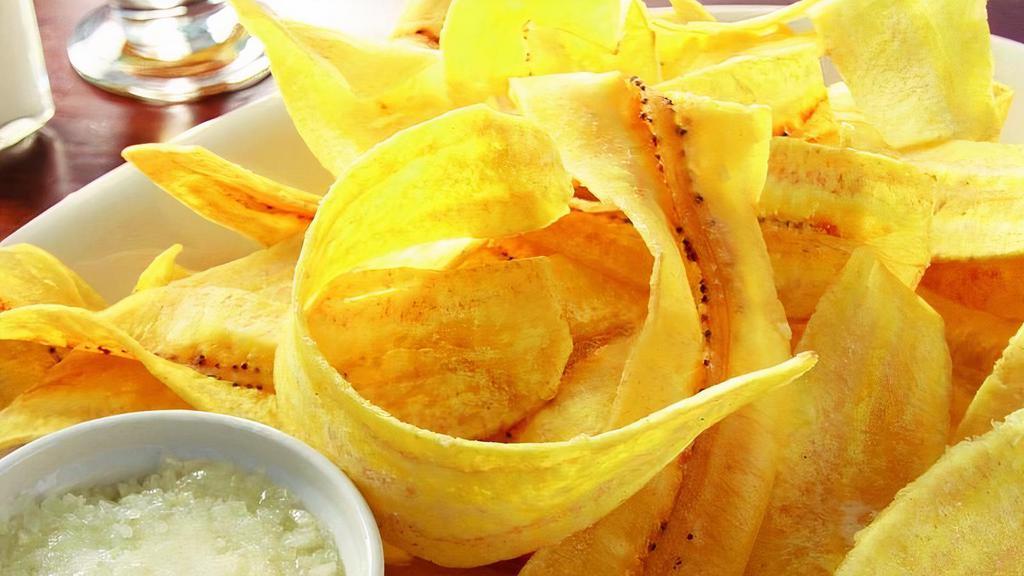 Mariquitas-Plantains Chips · Green plantains thinly sliced and fried, topped with mojito sauce (Garlic sauce).