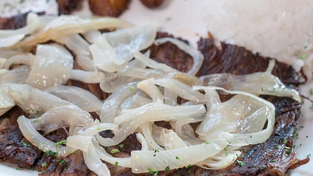 Fried Beef · A flavorful flank steak cooked on the grilled, topped with sauteed onions. Served with white rice, black beans and sweet plantains.