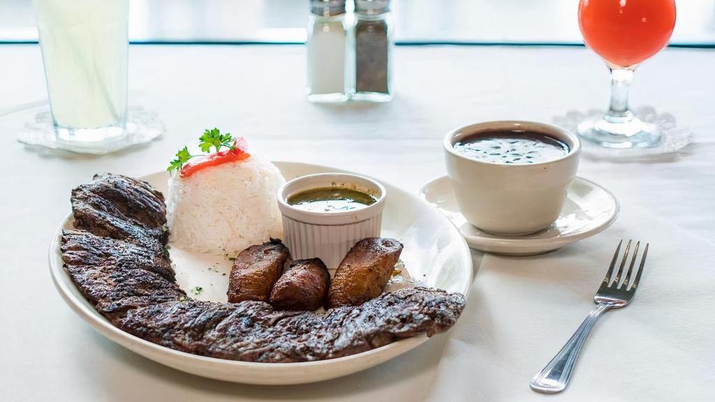 Skirt Steak · A juicy tender skirt steak, grilled to your liking. Served with chimichurri sauce. Served with white rice, black beans and sweet plantains.
