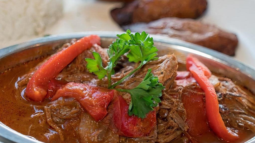 Shredded Beef · Thinly shredded flank beef cooked in tomato base sauce and marinated in garlic, bell peppers, onions, bay leaves, and more. A cuban tradition. Served with white rice, black beans and sweet plantains.