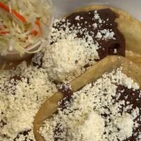 Charras Nica · 3 Fried Tortillas With Mashed Beans, Crumbled Cheese & Cabbage.