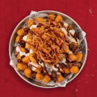 Loaded Tots · Golden fried tater tots topped with crispy onion straws, queso and drizzled with BBQ Sauce.
