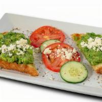Avocado Toast · Avocado spread on waffled sourdough bread served with cucumber, tomato, feta, and dusted wit...