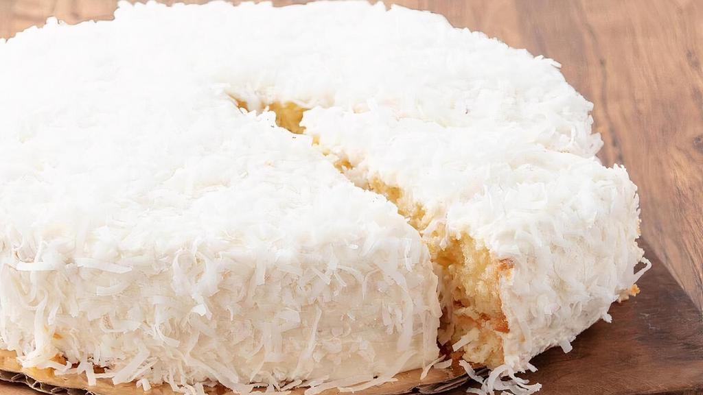 Whole Coconut Cream Cake · Moist coconut syrup-soaked white cake layers filled with creamy coconut custard and sweet toasted coconut finished with coconut flavored topping and coconut.