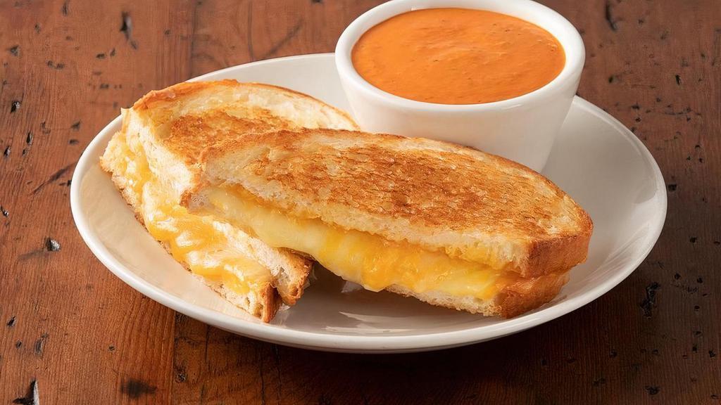 Grilled Cheese Sandwich · Cheddar, Provolone, Swiss and Parmesan cheese melted between two slices of butter toasted country bread and served with a cup of our Famous Tomato Basil Soupe.
