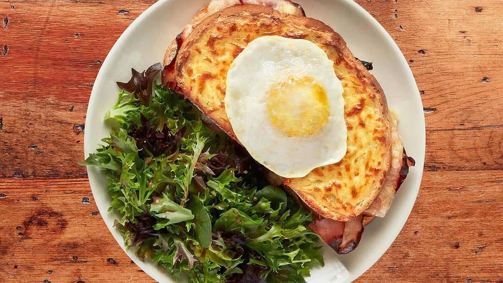 Croque Madame · Smoked ham & Swiss with garlic cream sauce baked on new country bread. Topped with a fried egg and served with a side of wild field salade.