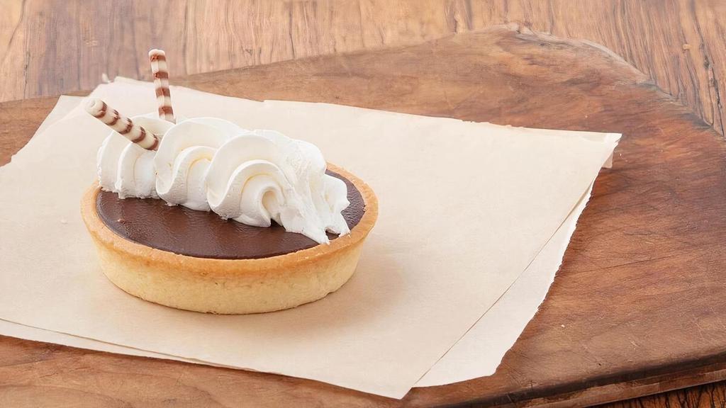 Chocolate Tart · Flaky vanilla pastry shell filled with smooth chocolate pastry cream and topped with whipped topping and a chocolate flute.