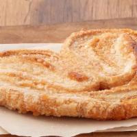 Palmier · Flaky pastry dough layered with sugar and butter, baked until golden brown.