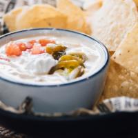 Cajun Queseaux® · Melted blend of cheeses, with sour cream, jalapenos, diced tomatoes.  Served with warm torti...
