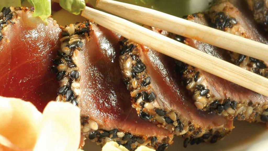 Seared Ahi Tuna · Sushi grade ahi tuna rolled in seasonings and sesame seeds, seared rare, mixed greens, wasabi, ginger and a side of sesame ginger dressing.