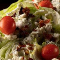 Bleu Cheese Wedge · Chilled iceberg, cucumbers, grape tomatoes,  crispy bacon, bleu cheese crumbles, cracked bla...