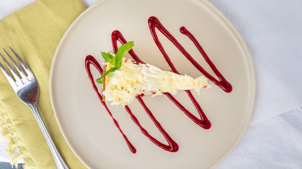 House-Made Key Lime Pie · Graham cracker crust with a tart and tangy filling and a side of raspberry puree and whipped cream.