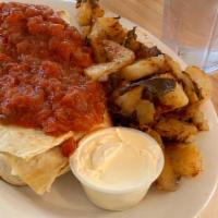 Breakfast Burrito · Scrambled eggs with sausage, Cheddar and grilled onions topped with sour cream and salsa (ba...