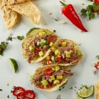 Pulled Brisket Taco · Brisket, tomatillo salsa, avocado, cilantro, lime, and thin cabbage.