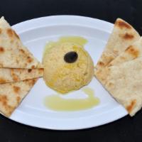 Hummus · Creamy hummus (spread made from chickpeas, olive oil, lemon juice and garlic) served with sl...