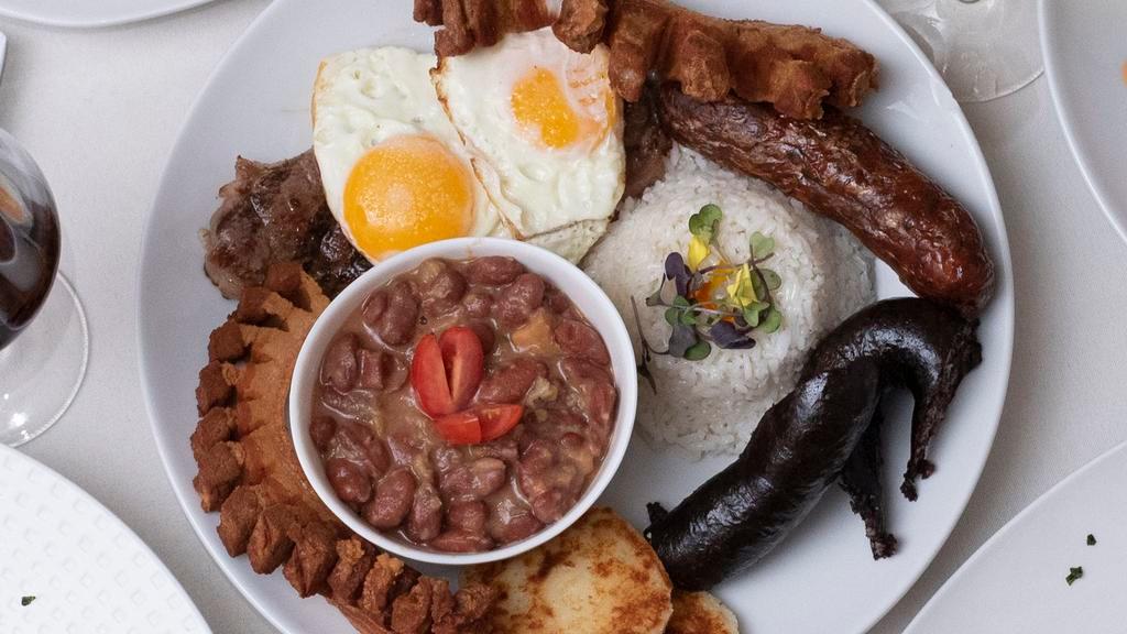 Bandeja Paisa · Typical Colombian plate filled with your choice of meat and served with rice, beans, egg, sweet plantains, chorizo, chicharrón, avocado and arepita.