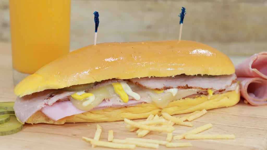 Sandwich Media Noche · Pan de media noche, jamón regular, jamón de pierna, queso suizo, pepinillo, mostaza, mayonesa y papitas fritas (Potato Stix)