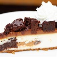 Caramel Brownie Bite Cheesecake Slice · white chocolate, dulce de leche caramel, brownie chunks, whipped cream