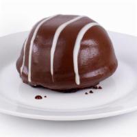 New! Tuxedo Bomb · A rich chocolate cake base is layered with milk chocolate & white chocolate mousse and cover...