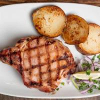 Chuleta De Puerco Ahumada · 2 Smoked pork chops with grilled onions.