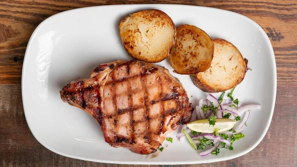 Chuleta De Puerco Ahumada · 2 Smoked pork chops with grilled onions.