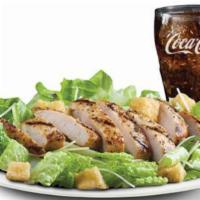 Grilled Chicken Caesar Salad Meal · Caesar salad topped with grilled chicken breast and a drink.