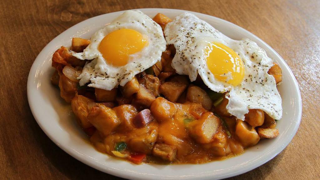 Sunny O'Ryan · Home Fries topped with smoked ham, red and green peppers, grilled onions and melted cheddar cheese topped with two sunny side up eggs. (1055 cal)