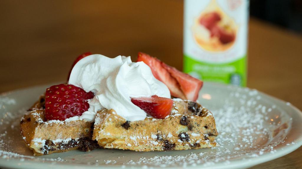 Little Grace · Half of a chocolate chip waffle topped with strawberries, powdered sugar, whipped cream and maple syrup.