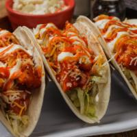 Buffalo Chicken Tacos Trio · Crispy breaded and baked chicken breast tossed in our Medium Buffalo sauce, sitting atop shr...