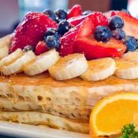 Florida Pancakes · Topped with fresh strawberries, banana, blueberries, and powdered sugar.